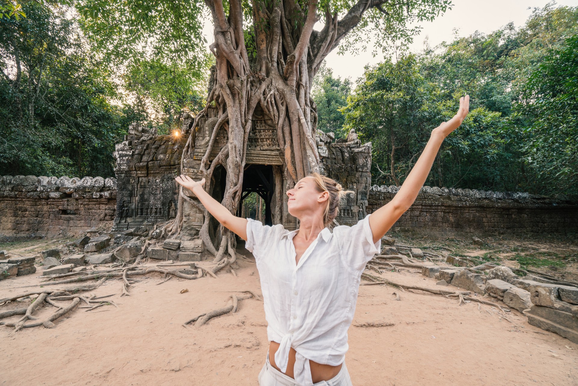 Junge Frau Reisen in Kambodscha besuchen die Tempel von Angkor Wat Komplex stehen ausgestreckten Armen. Die Leute reisen Entdeckung Asien Konzept. Sonnenuntergang, eine Frau nur, Abenteuer und Entdeckungen in Siem Reap, Südost-Asien beschossen.