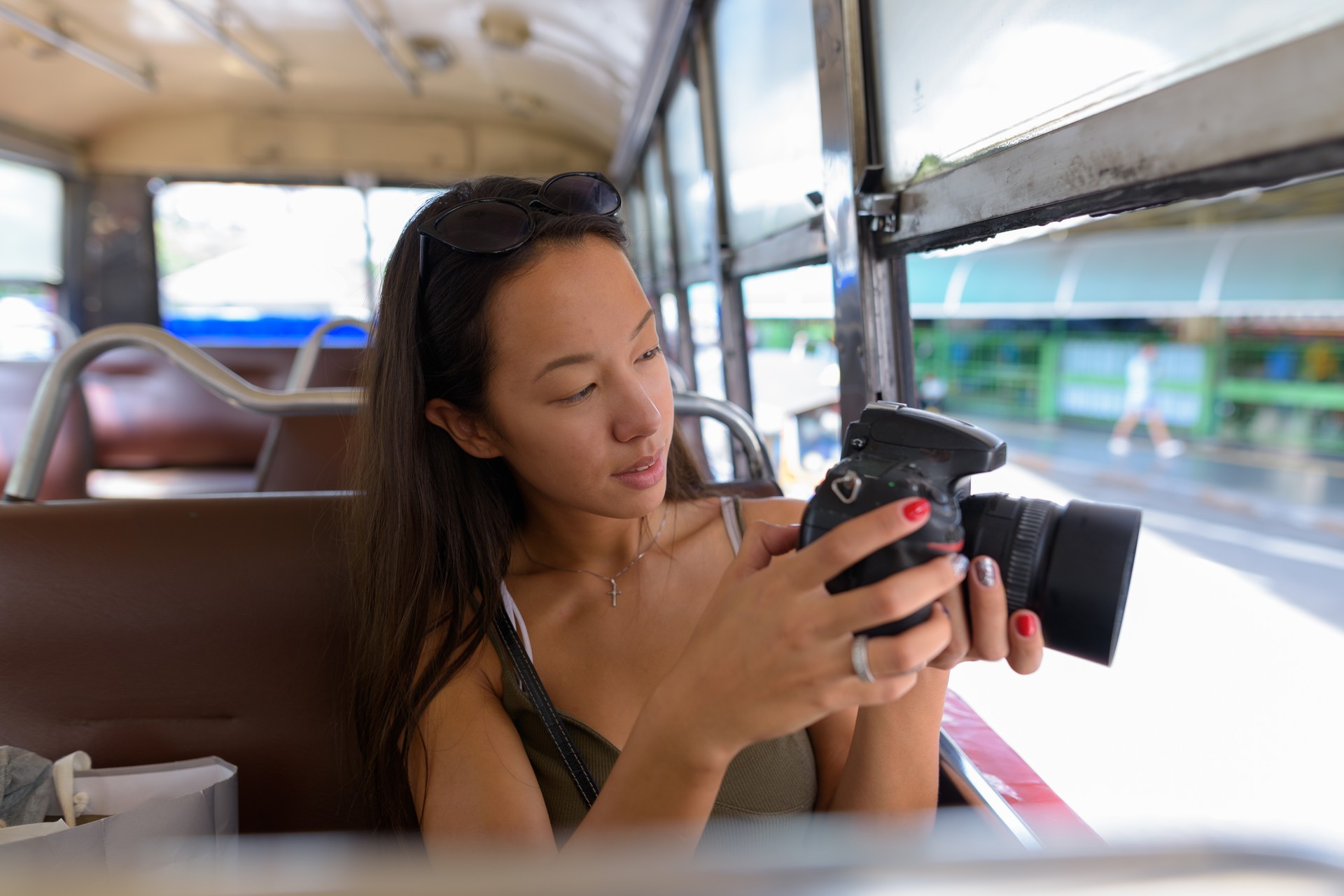 Porträt des jungen schönen multi-ethnischen touristischen Frau Fahrt mit dem Bus rund um Bangkok Thailand